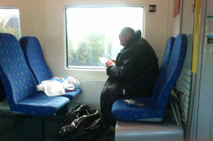 Denna man satt på tåget och klippte itu etiketter för att sedan klistra fast de på importerade PET-flaskor. Funkar tricket? Högst oklart.